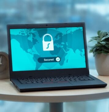 Laptop z ikoną kłódki na biurku, symbol bezpiecznego internetu w biurze